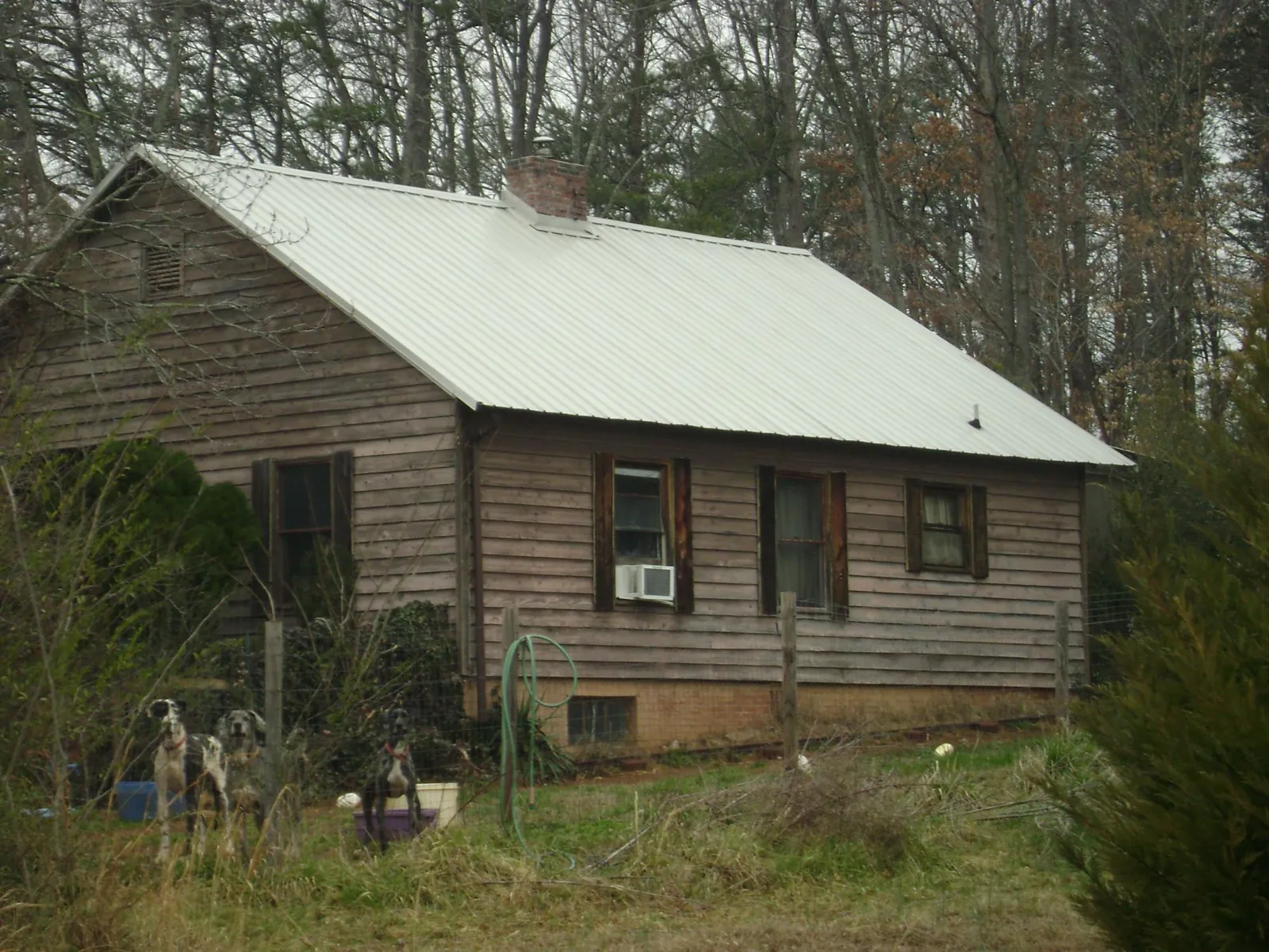 White metal roof on an old wood sided farmhouse, from a Metal Roof Installation job in Malaga